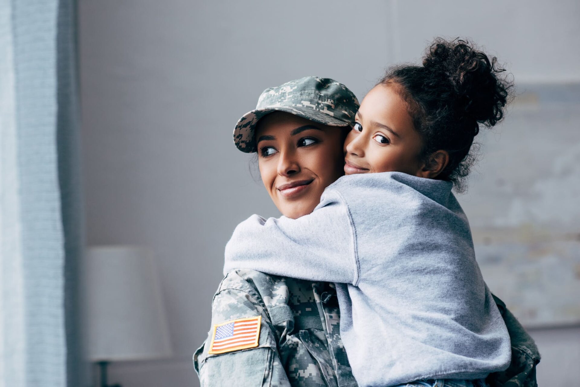 Mother with a military uniform hugging her daughter