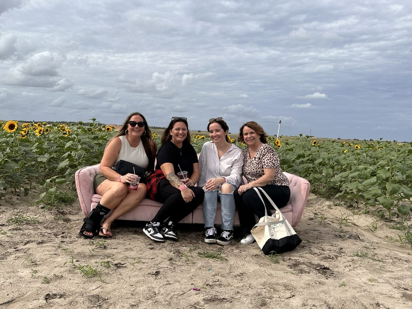 4 women smiling at a camera on a farm