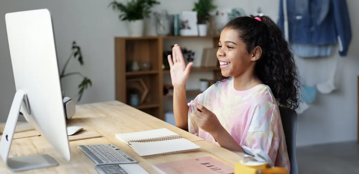 Student waiving at her online class