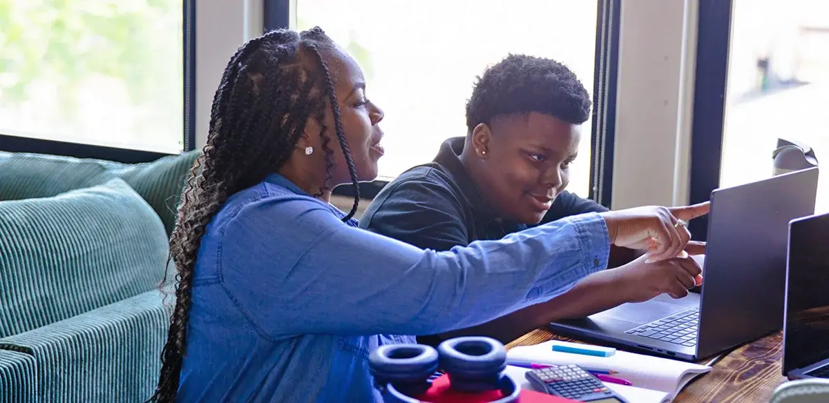 Mother and son working together with their laptop at home