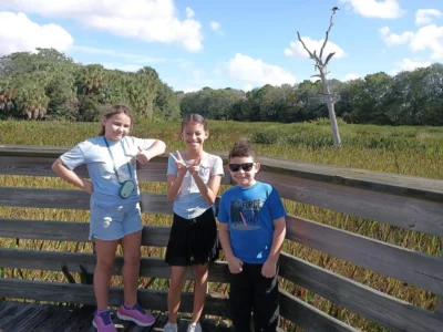 Three small kids standing and smiling
