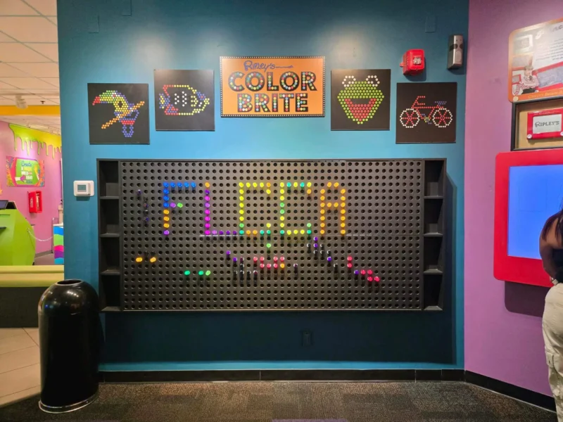 Colorful peg wall display featuring the word "FLCCA" in vibrant hues.