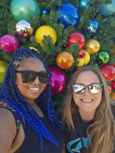 Girl with blue hair smiling next to blonde girl